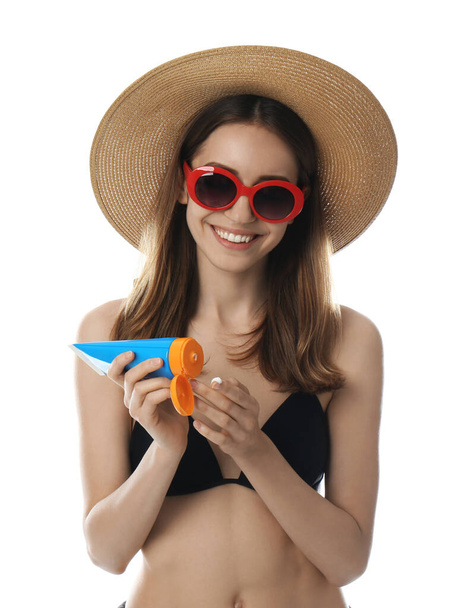 Mujer joven aplicando crema de protección solar sobre fondo blanco
 - Foto, Imagen