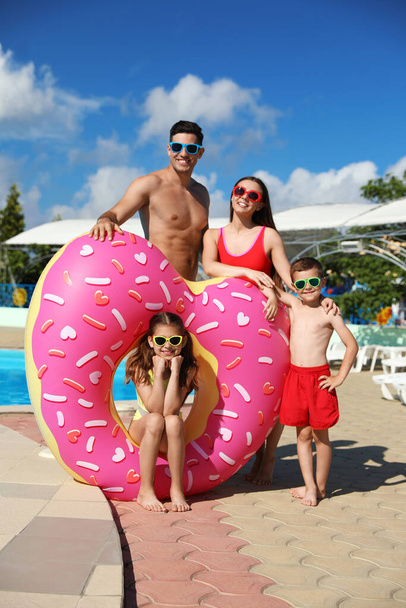 Happy family with inflatable ring near swimming pool.  Summer vacation - Fotoğraf, Görsel