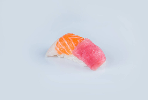 Japanilainen Nigiri sushi kolmenlaisia kaloja: raaka lohi, tonnikala ja rockfish. sashimi riisillä, eristäminen harmaalla pohjalla. Japanilaista ruokaa. Pan Aasian ruokalaji eristetty. - Valokuva, kuva