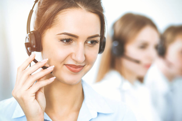 Call center. Focus on beautiful business woman in headset - Zdjęcie, obraz