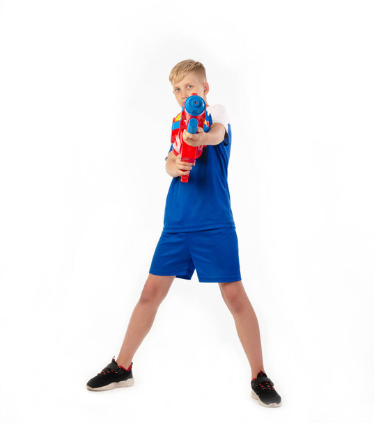 niño con pistola de agua sobre fondo blanco
 - Foto, imagen