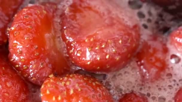 Strawberry jam in its own juice is cooked in an open bowl close-up macro video zoom and camera movement apply food background - Footage, Video