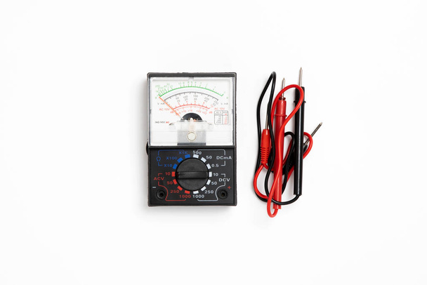 Zwart digitaal multimeter elektronisch meetapparaat met rode en zwarte kabels geïsoleerd op witte achtergrond.Hoge resolutie foto. - Foto, afbeelding