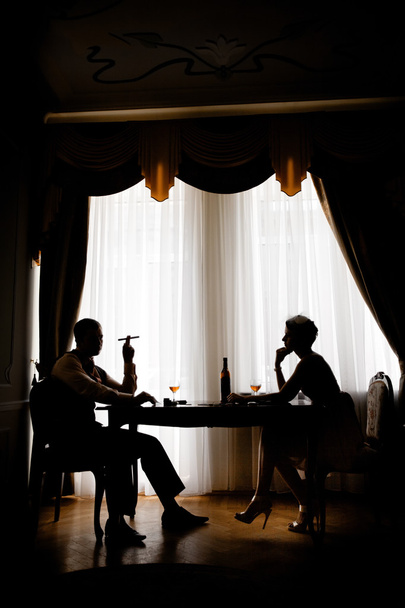 Hermosa pareja en el rincón oscuro de un restaurante
 - Foto, imagen