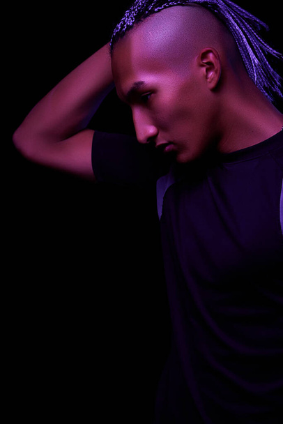 portrait of a young naked african man at studio. High Fashion male model in colorful neon bright lights posing on black background. Art design concept. selective focus. - Foto, Bild