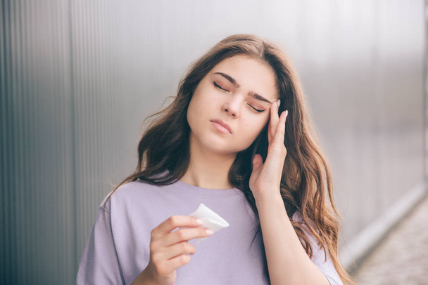 Young stylish trendy woman isolated over grey blue background. Sick ill girl has teriible strong headache. Suffer from pain in head. Alone outside. - Fotoğraf, Görsel