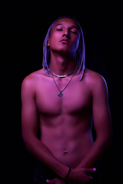 portré egy fiatal meztelen afrikai férfiról a stúdióban. High Fashion férfi modell színes neon fényes fények pózol fekete háttér. Art design koncepció. szelektív fókusz. - Fotó, kép
