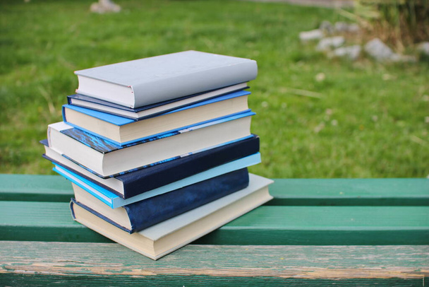 Куча книг на скамейке в школьном парке
 - Фото, изображение