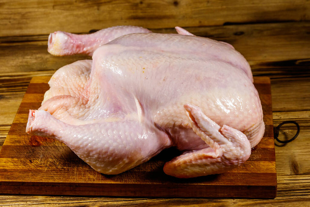 Pollo intero crudo su un tavolo di legno - Foto, immagini