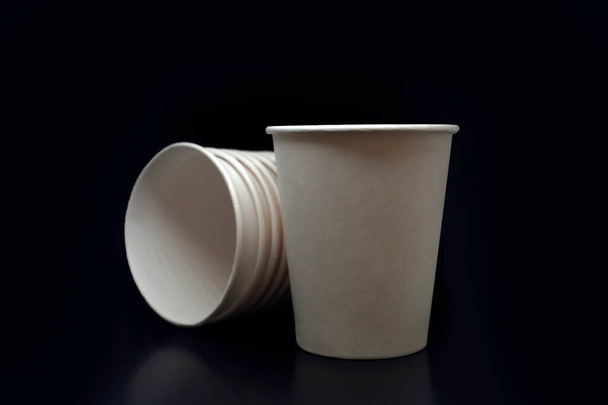 Папір текстуровані білі порожні одноразові чашки для напоїв, забирають на чорному ізольованому фоні
 - Фото, зображення