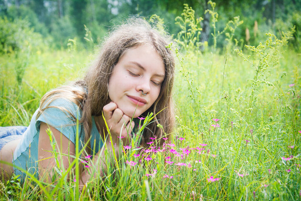 V létě, dívka se zavřenýma očima leží na květinové louce. - Fotografie, Obrázek