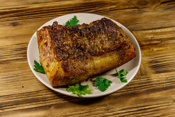 Baked pork belly in a plate on wooden table - Photo, Image