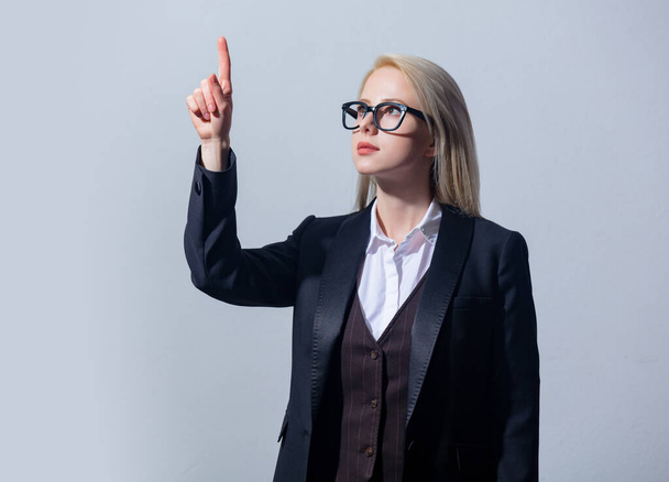 Beautiful blonde businesswoman in suit on gray background  - Foto, Imagem