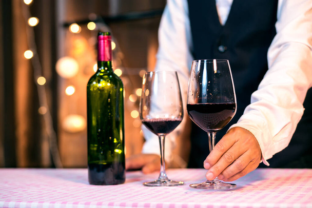 Σερβιτόρα άνθρωπος ρίχνει κρασί στο ποτήρι - Φωτογραφία, εικόνα