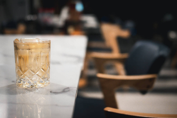 Whisky en un vaso de cristal con cubitos de hielo en la cena de mesa
 - Foto, imagen