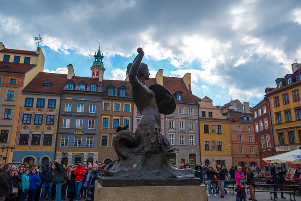 Warsaw, Poland - April 01, 2019: Bronze statue of Mermaid on the Old Town Market Square surrounded by colorful old houses - Photo, Image