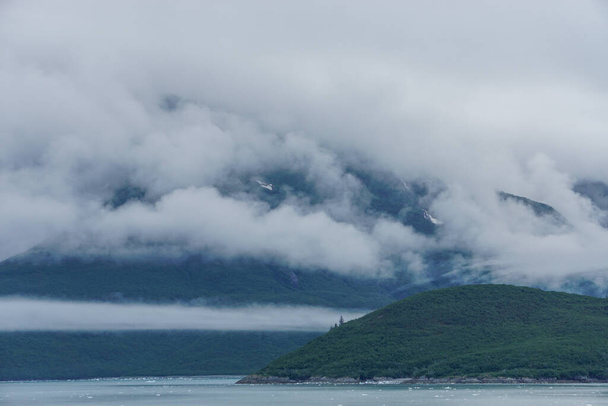 Yakutat Bay, Alaska, Estados Unidos: Nubes que descienden sobre una ladera en el borde de la bahía de Yakutat
. - Foto, imagen
