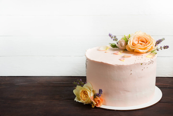 Beautiful roses cake on wooden board Peach roses and lavender cake, Concept for Wedding , St. Valentine's Day, Mother's Day, Birthday Cake. White background - Photo, Image