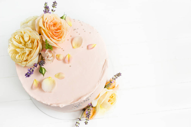 Beautiful roses cake on wooden board Peach roses and lavender cake, Concept for Wedding , St. Valentine's Day, Mother's Day, Birthday Cake. White background - Photo, Image