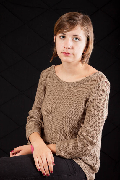 Довольно задумчивая женщина в коричневом свитере
 - Фото, изображение
