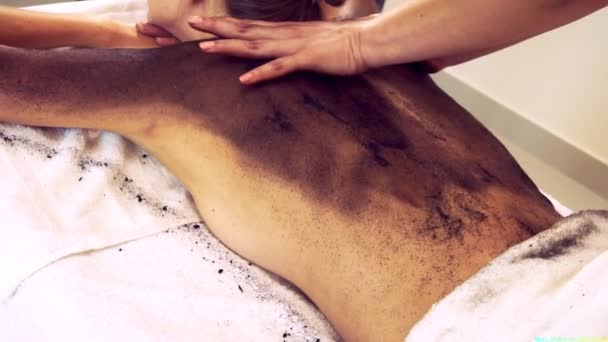 Donna rilassata sdraiata sul letto spa per massaggio detergente corpo utilizzando erbe tradizionali - Filmati, video