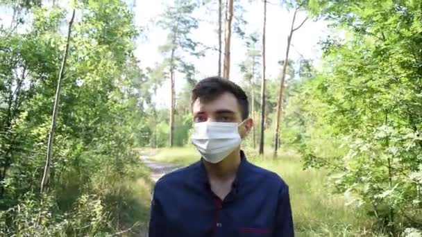 Giovane con una maschera medica nella foresta. Virus, malattia - Filmati, video