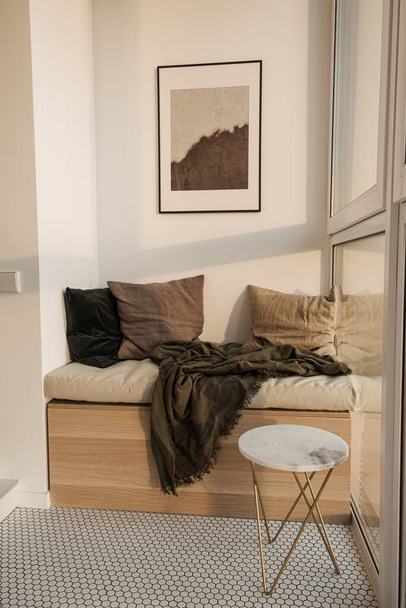 Stílusos modern hangulatos belsőépítészeti koncepció: fa nyugágy, kockás, párnák, márvány asztal, képkeret, mozaik csempe. Minimális kényelmes társalgó pihenés pihenőhely loggia - Fotó, kép