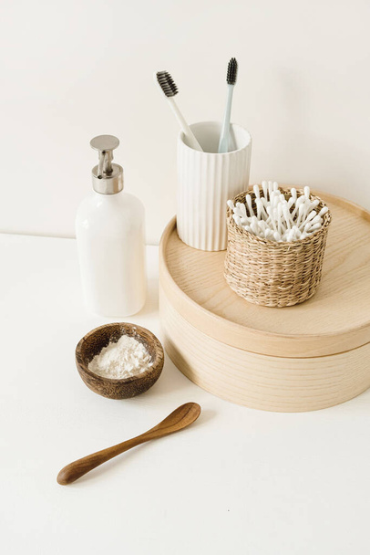 Beauty, health care morning routine products. Spa, wellness, treatment essentials. Toothbrushes, ear sticks, liquid soap cream on white table - 写真・画像