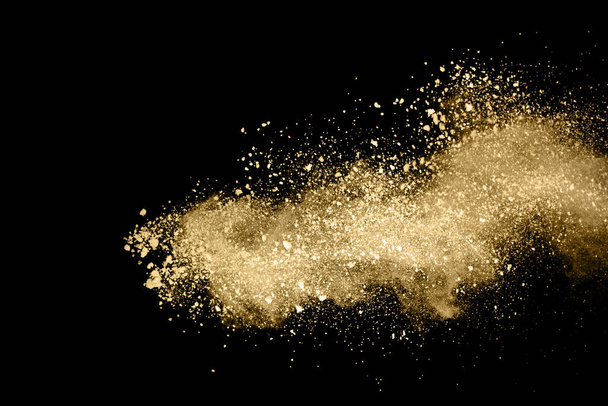 Goldene Pulverexplosion auf schwarzem Hintergrund. Gefrierbewegung. - Foto, Bild