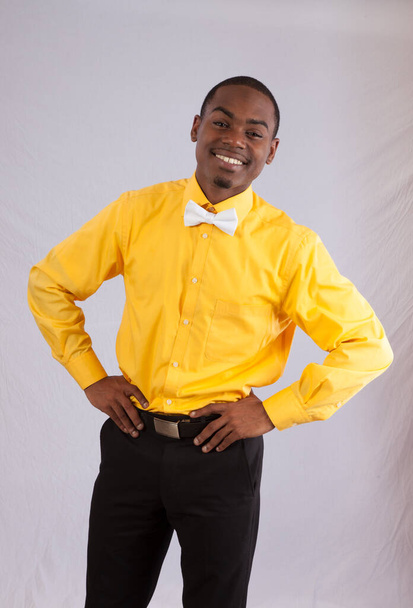 Szczęśliwy czarny mężczyzna w żółtej koszuli i białej muszce - Zdjęcie, obraz