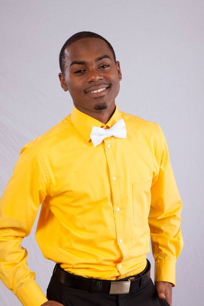 幸せな黒男で黄色のシャツと白の蝶ネクタイ - 写真・画像