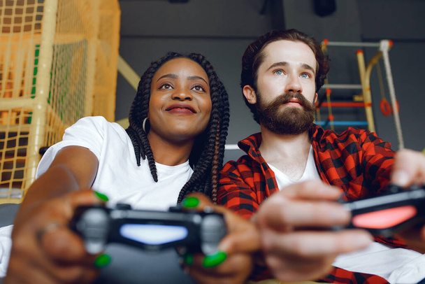 International couple playing a video games - Foto, afbeelding