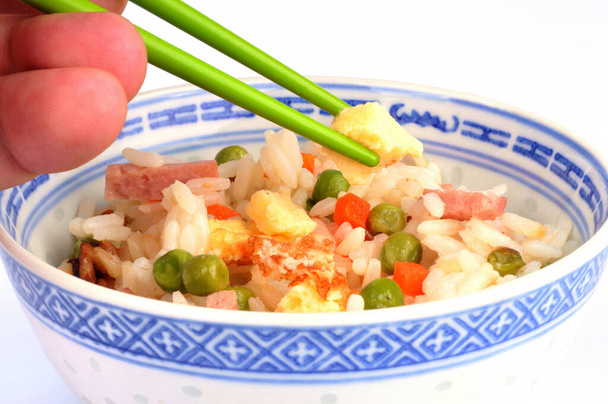 Bowl of Cantonese rice close up with chopsticks on white background | Bol de riz cantonais en gros plan avec des baguettes chinoises sur fond blanc - Photo, Image