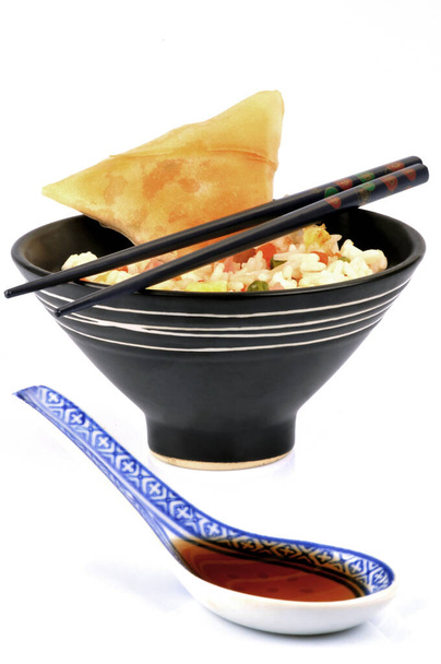Bowl of Cantonese rice with samosas and soy sauce close-up on white background | Bol de riz cantonais avec des samoussa et de la sauce soja en gros plan sur fond blanc - 写真・画像