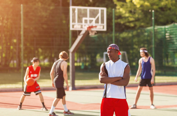 Afroamerykańska koszykarka z różnorodnym zespołem stojącym na boisku do gry na świeżym powietrzu, puste miejsce - Zdjęcie, obraz