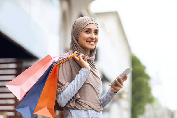 Sorridente ragazza in hijab avendo shopping giorno - Foto, immagini