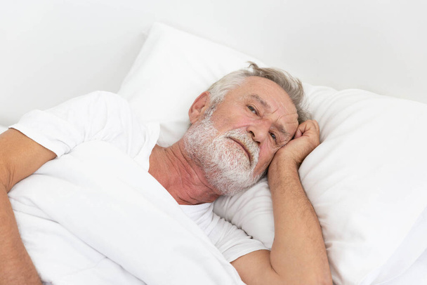 Worried senior retirement man lying awake in his bed - Foto, Imagem