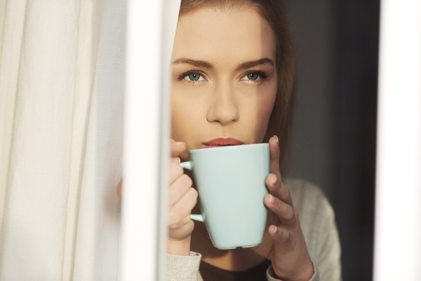 Beautiful caucasian woman drinking hot coffee or tea. - 写真・画像