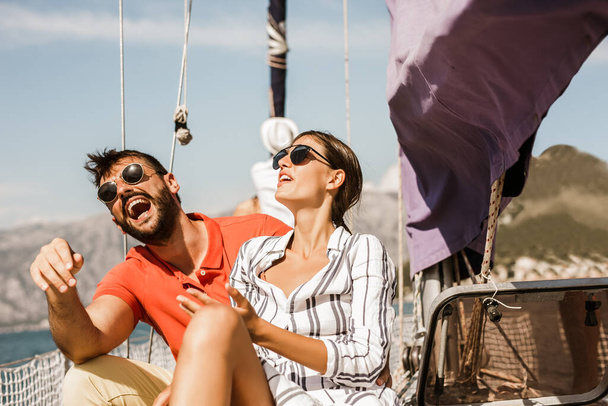 Szerető pár töltenek boldog időt egy jachton a tengeren. Luxus nyaralás a tengerparton.  - Fotó, kép