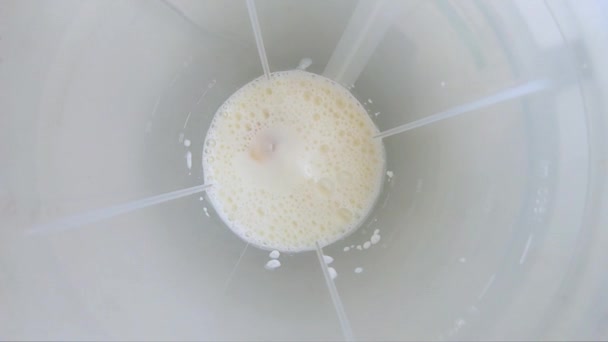 Banana smoothie with milk spinning in a blender. Top view and slow motion. GOPRO. - Video