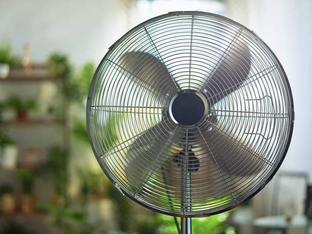 Summer heat. modern metallic floor stand electric fan in the modern house in sunny hot summer day. - Foto, Imagem