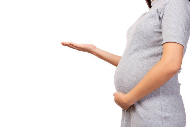 Schwangere Mutter öffnet Handfläche, um Raum zu kopieren und ihren Bauch zu berühren. Schwangere zeigen leere Handflächen. Isoliert auf weißem Hintergrund, Kopierraumnutzung für Werbung Pränatal, Schwangerschaftskonzept - Foto, Bild