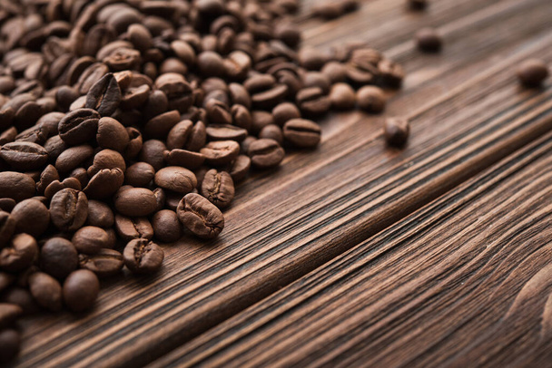 Detailní záběr na přírodní kávová zrna na dřevěném stole - Fotografie, Obrázek