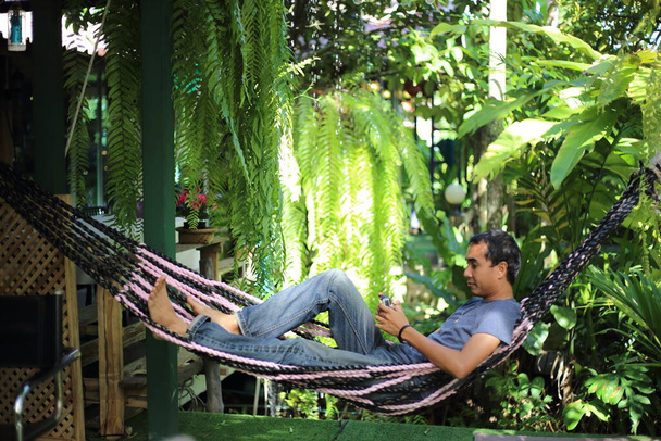 Człowiek siedzi w ogrodzie z zielonych roślin - Zdjęcie, obraz