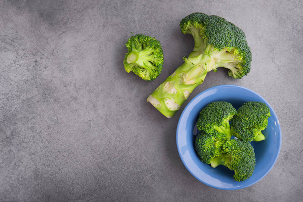 Frischer roher grüner Brokkoli auf einem Tisch. Ernähren Sie sich gesund. Ansicht von oben - Foto, Bild