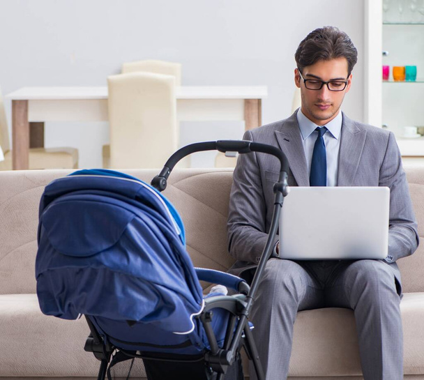 Businessman looking after newborn baby at home and teleworking - Foto, Bild