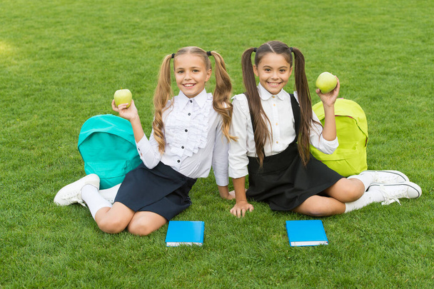 Vitamin works wonders. Happy children hold apples on green grass. School break. Vitamin snack. Choosing vitamin fruit. Eating right carbs. Vitamin and raw food. Energy diet - 写真・画像