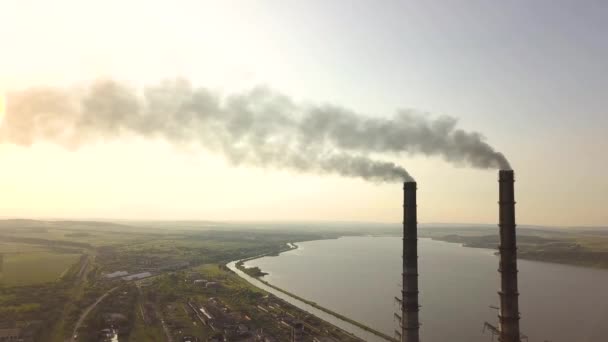 Luchtfoto van hoge schoorsteenpijpen met grijze vuile rook van kolencentrales. Productie van elektriciteit met fossiele brandstoffen. - Video