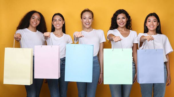 Happy Girls Showing Shopper Bags Standing Over Yellow Background, Mockup - Photo, Image