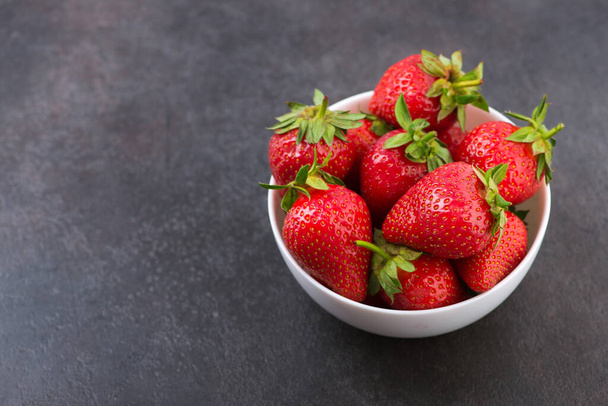 Fresh red strawberry in a bowl on table. Yammy summer dessert. - Foto, afbeelding